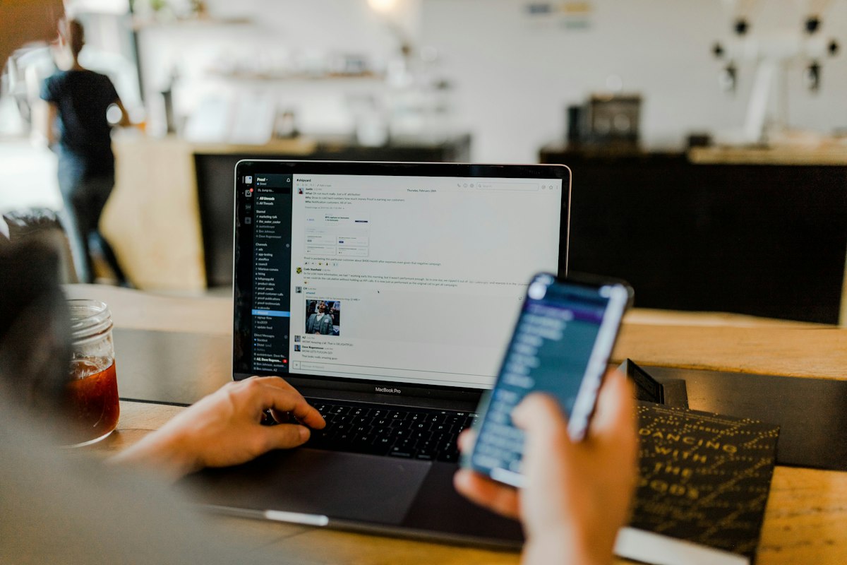 Person chatting on a laptop and phone