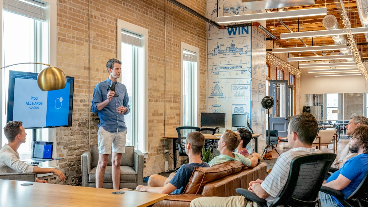 Man presenting to a group in a bright office